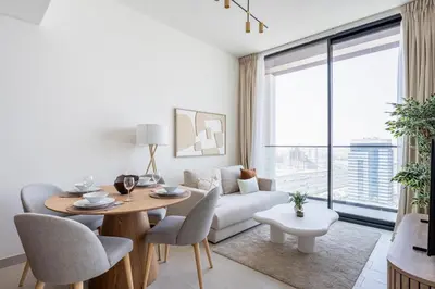 a living room with a table and a couch at GuestReady - Top-Floor Tranquillity in JVC in Dubai