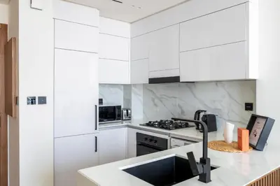 a kitchen with white cabinets and a sink at GuestReady - Top-Floor Tranquillity in JVC in Dubai