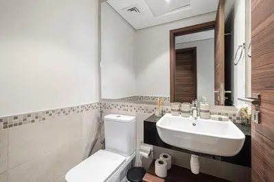 a bathroom with a white toilet and a sink at Lush 1BR Oasis in JVC With Gym & 5min to Circle Mall in Dubai