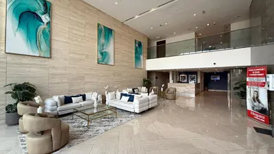a lobby with couches and tables in a building at Lush 1BR Oasis in JVC With Gym & 5min to Circle Mall in Dubai