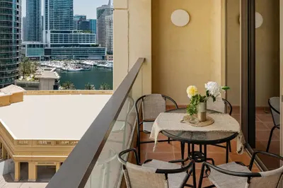 a balcony with a table and chairs and a view of a city at Rimal 3, JBR - Studio Apartment - Allsopp & Allsopp in Dubai