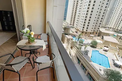 a balcony with a table and chairs and a pool at Rimal 3, JBR - Studio Apartment - Allsopp & Allsopp in Dubai