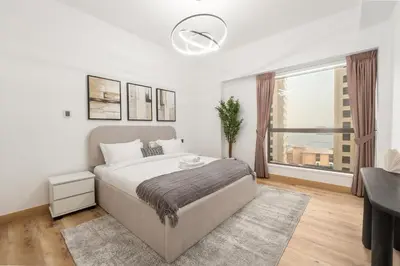 a bedroom with a large bed and a large window at 4 Bedroom Sea View Apartment in Jumeirah Beach Residence in Dubai