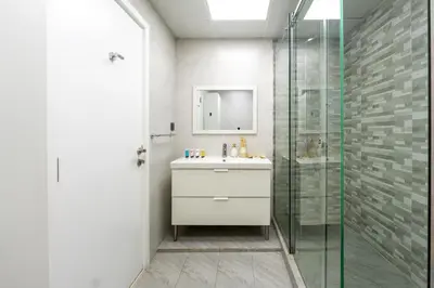 a bathroom with a sink and a glass shower at 4 Bedroom Sea View Apartment in Jumeirah Beach Residence in Dubai