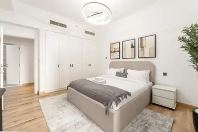 a white bedroom with a large bed and white cabinets at 4 Bedroom Sea View Apartment in Jumeirah Beach Residence in Dubai