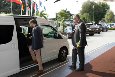 two men are standing next to a white van at Royal Rider Bus rental Dubai in Dubai