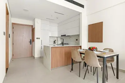 a kitchen and dining room with a table and chairs at Vayk - Modern 1BR Apartment in JVC in Dubai