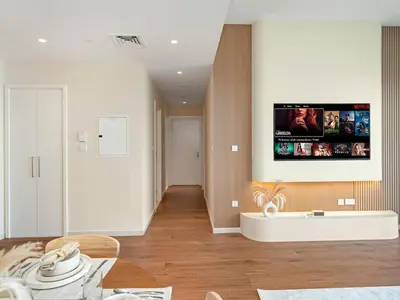 a living room with a tv on the wall at Dubai Hills 2BR Full Park View and Designer Style in Dubai