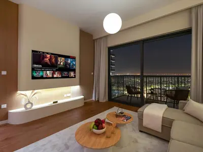 a living room with a couch and a large window at Dubai Hills 2BR Full Park View and Designer Style in Dubai