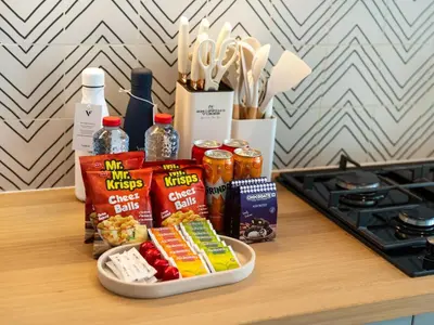 a counter top with a tray of food and snacks at Modern 1BR with Cinema, Pool and Gym Dubai Hills in Dubai