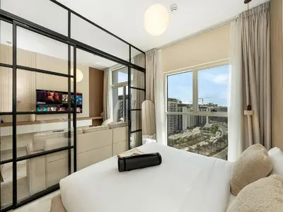 a bedroom with a white bed and a large window at Modern 1BR with Cinema, Pool and Gym Dubai Hills in Dubai