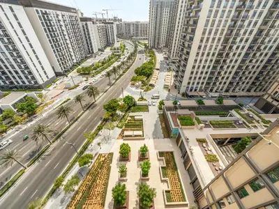 an empty street in a city with tall buildings at Modern 1BR with Cinema, Pool and Gym Dubai Hills in Dubai