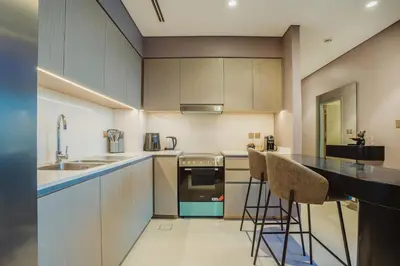 a kitchen with a counter and some chairs in it at Bitcoin Moonrise 2BR - Grande Burj Views in Dubai
