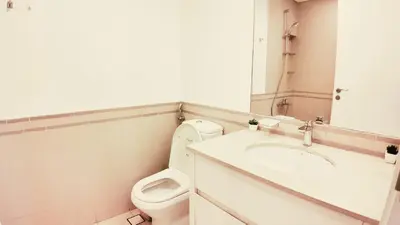a bathroom with a toilet and a sink and a mirror at Silk Valley - Modern 2BR Near Park & Attractions in Dubai