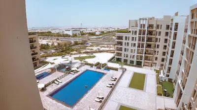 an aerial view of a swimming pool in a apartment complex at Silk Valley - Modern 2BR Near Park & Attractions in Dubai