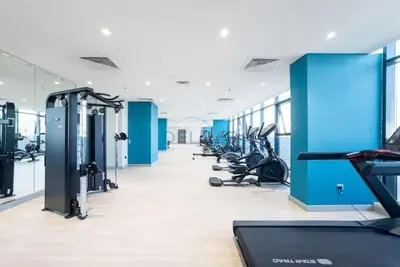 a gym with several treadmills and cardio machines at Peaceful 1BR with Community View, Quick Downtown and Golf Club Access, Azizi Riviera 34, Al Merkadh by Deluxe Holiday Homes in Dubai