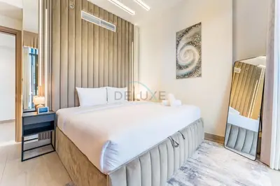 a bedroom with a large white bed and a window at Peaceful 1BR with Community View, Quick Downtown and Golf Club Access, Azizi Riviera 34, Al Merkadh by Deluxe Holiday Homes in Dubai