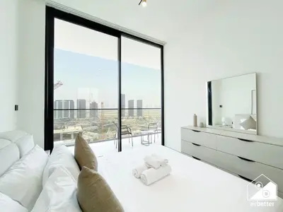a bedroom with a white bed with a large window at Stylish 1BR Retreat in Binghatti Amber l Balcony in Dubai