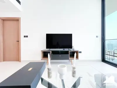 a living room with a tv and a table at Chic Binghatti Amber 1BR l Balcony & Comfort in Dubai