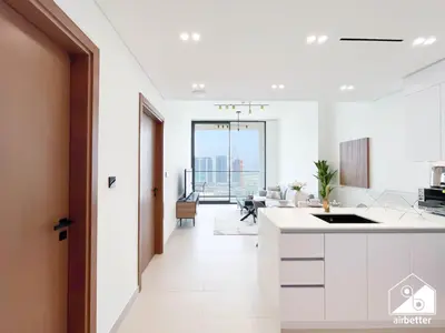 an open kitchen with white cabinets and a living room at Chic Binghatti Amber 1BR l Balcony & Comfort in Dubai