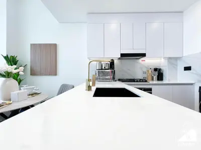 a kitchen with white cabinets and a sink at Chic Binghatti Amber 1BR l Balcony & Comfort in Dubai