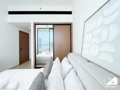 a living room with a white couch and a mirror at Chic Binghatti Amber 1BR l Balcony & Comfort in Dubai
