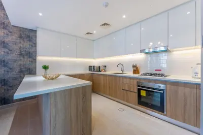 a large kitchen with wooden cabinets and a counter top at Unique & Stunning Marina Views LIV Residence 2BR in Dubai