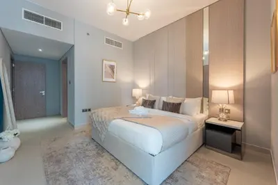a bedroom with a large white bed and a night stand at Unique & Stunning Marina Views LIV Residence 2BR in Dubai