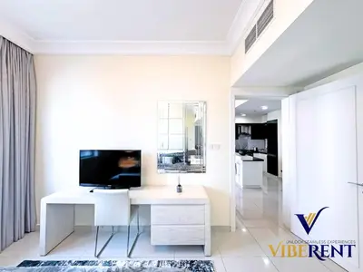 a living room with a white desk and a television at Hotel Apartment next to Dubai Mall,Views & Vibes in Dubai
