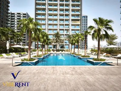a swimming pool with palm trees and a tall building at Damac 1BHK, Terrance Pool, 20 Min to Downtown in Dubai