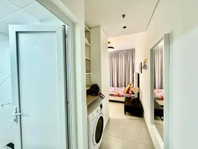 a bathroom with a washing machine in a room at Stunning studio with balcony close to metro in Dubai