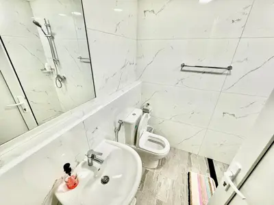 a white bathroom with a toilet and a sink at Stunning studio with balcony close to metro in Dubai