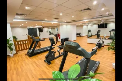 a gym with treadmills and ellipticals in a room at Dubai Downtown Canal View Studio 2306 in Dubai