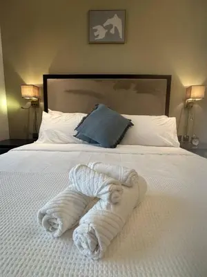 a bed with a pile of white towels on it at Dubai Downtown Canal View Studio 2306 in Dubai