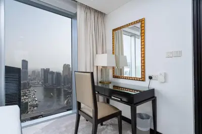a room with a desk with a mirror and a window at Waterfront Luxury 2 Bed in Marina Mall Hotel in Dubai