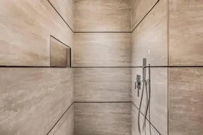 a bathroom with a shower with a wall at Brand New Luxury Studio in JVC in Dubai