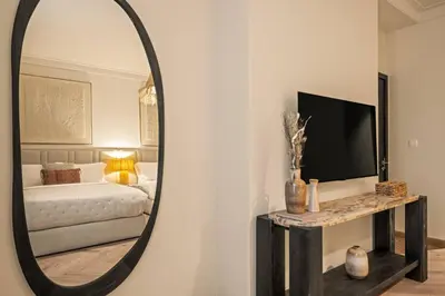 a mirror in a room with a bed and a television at Seraya at Dubai Creek South Residence in Dubai