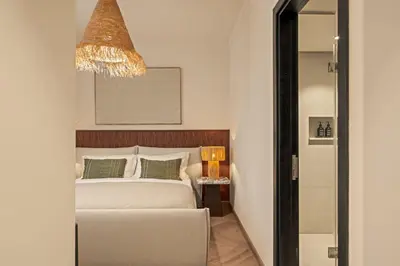 a bedroom with a bed and a chandelier at Seraya at Dubai Creek South Residence in Dubai