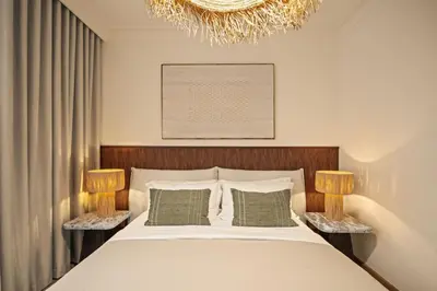 a bedroom with a bed with two lamps and a chandelier at Seraya at Dubai Creek South Residence in Dubai