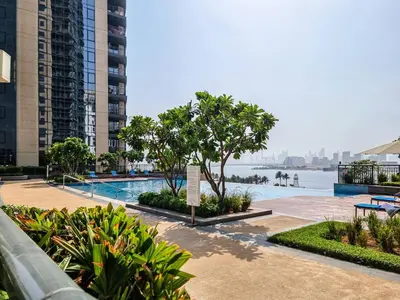 a swimming pool with a view of the water and buildings at Seraya at Dubai Creek South Residence in Dubai