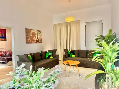 a living room with a couch and a table at Regent House 1 Motor City in Dubai