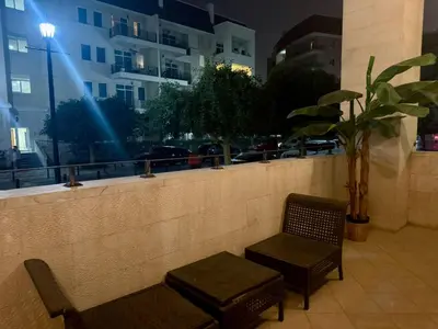 two chairs and a bench in front of a building at Regent House 1 Motor City in Dubai