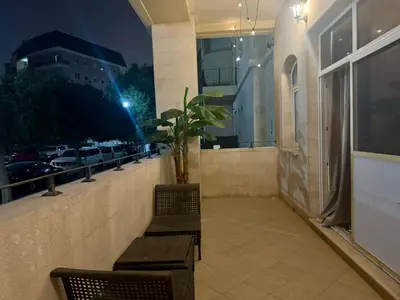 a balcony with two chairs and a potted plant at Regent House 1 Motor City in Dubai