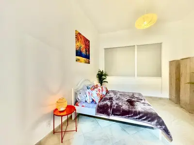 a bedroom with a bed and a table at Regent House 1 Motor City in Dubai