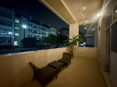 two benches sitting on a balcony at night at Regent House 1 Motor City in Dubai