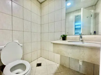 a bathroom with a toilet and a sink and a mirror at Regent House 1 Motor City in Dubai