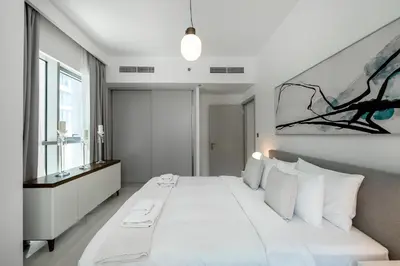 a white bedroom with a large bed with white pillows at Beach Isle 1 Emaar Beachfront - Mint Stay in Dubai