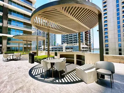 a patio with a table and chairs and a building at Beach Isle 1 Emaar Beachfront - Mint Stay in Dubai