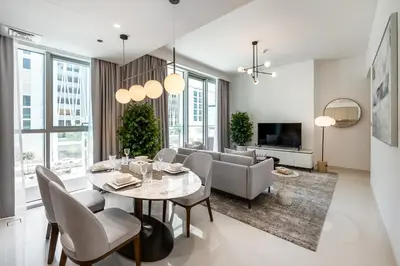 a dining room and living room with a table and chairs at Beach Isle 1 Emaar Beachfront - Mint Stay in Dubai
