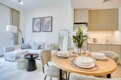a living room with a table and a couch at PVH - Charming 1 BR - Lotus Creek Beach in Dubai
